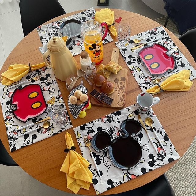 Mesa redonda com jogo americano e pratinhos do Mickey