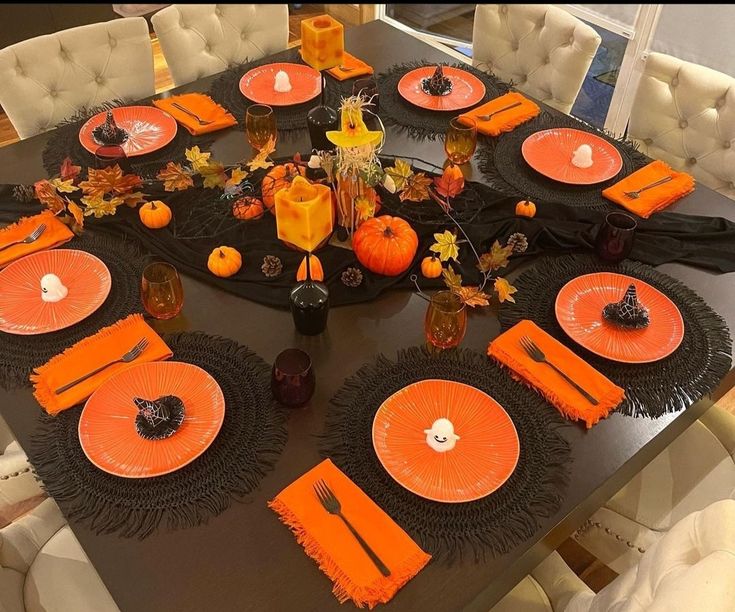 Mesa posta com pratos e guardanapos laranja