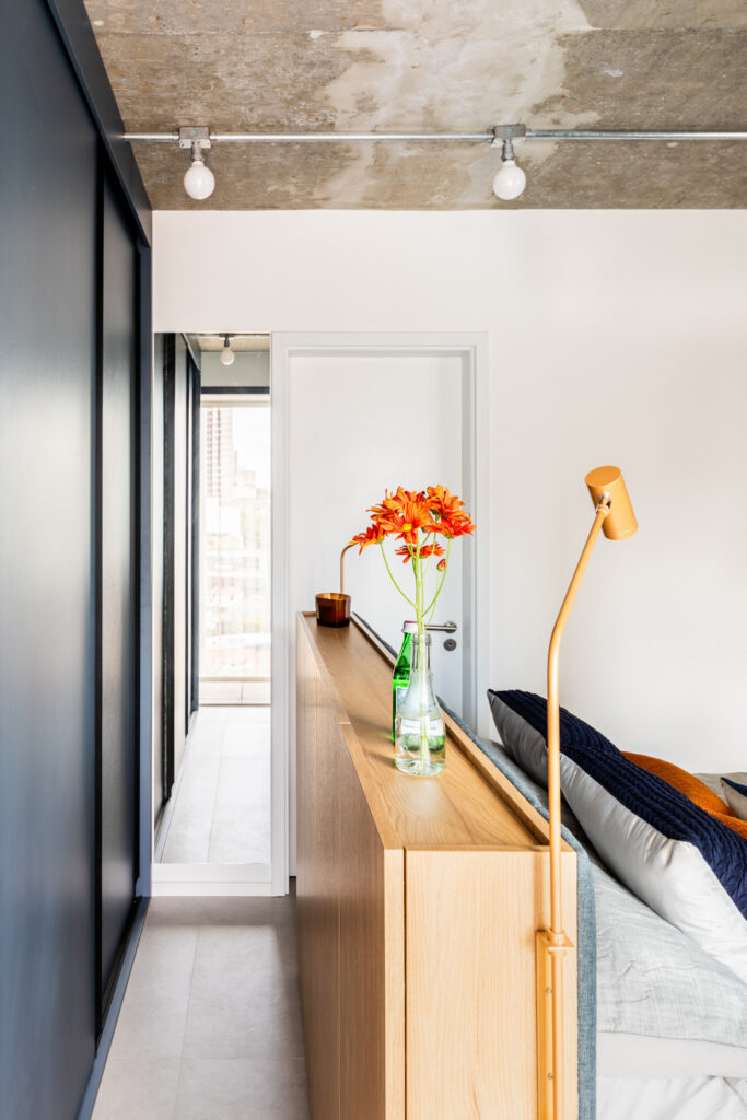 Quarto pequeno com armário azul e cabeceira em madeira