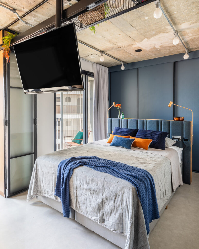 Quarto pequeno com armário azul e cabeceira em madeira