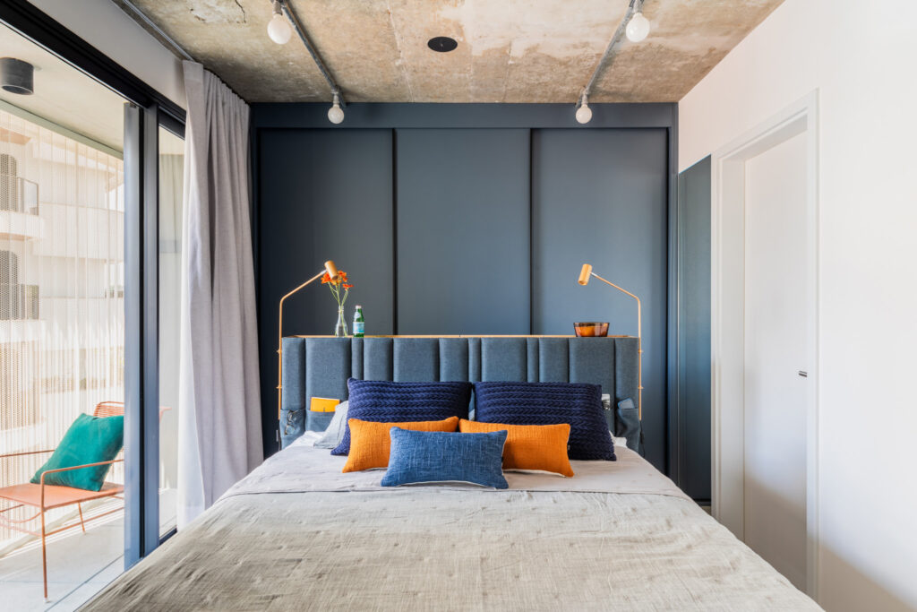 Quarto pequeno com armário azul e cabeceira em madeira