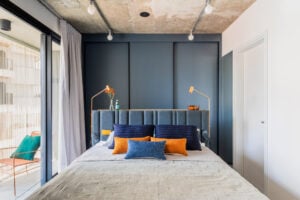 Quarto pequeno com armário azul e cabeceira em madeira
