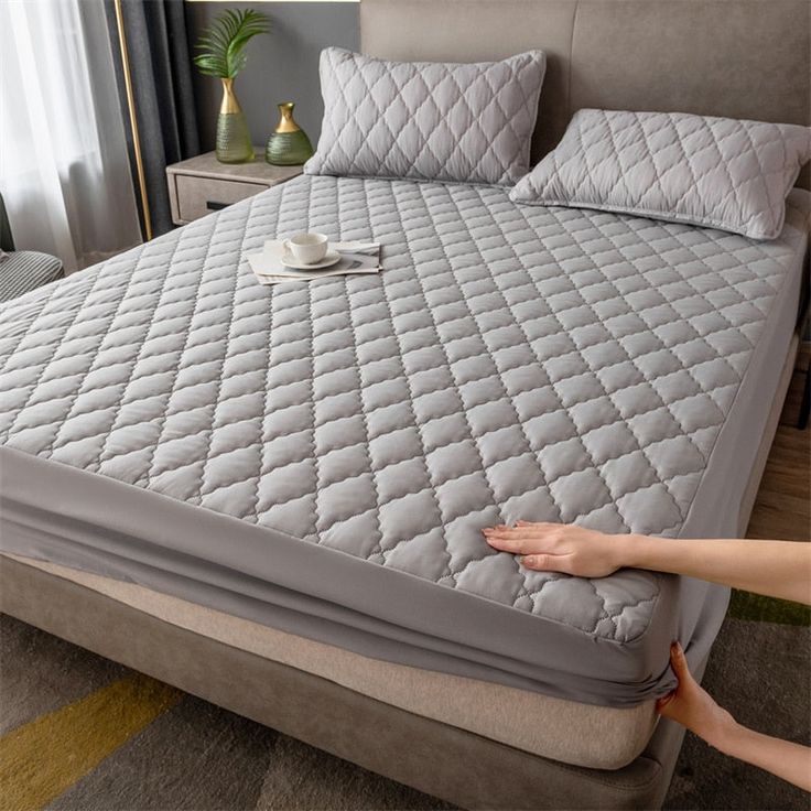 Cama com capa de colchão cinza