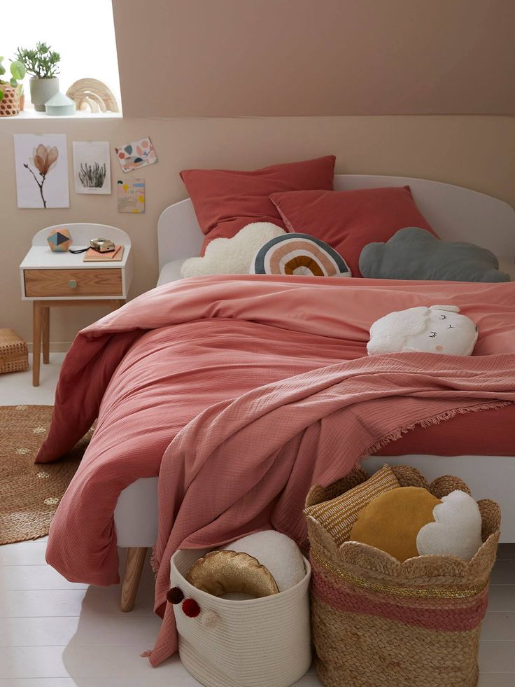 Quarto com edredom e lençóis em tons rosados
