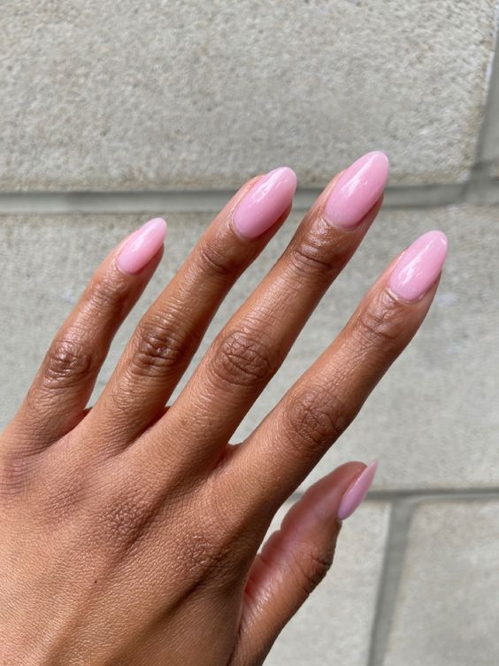 Mão de pele preta com unha amendoada rosa-claro 