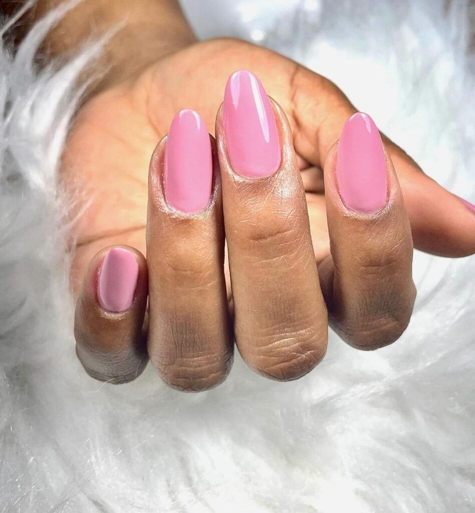 Mão de pele preta, com unha amendoada rosa-claro