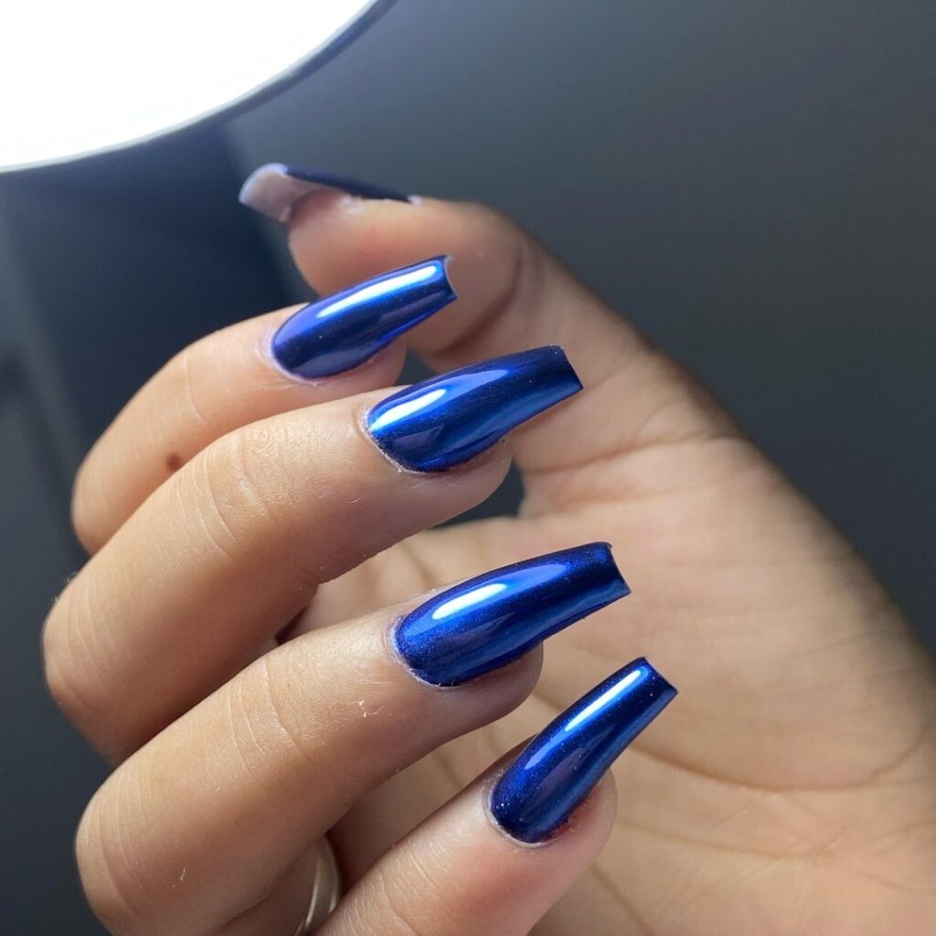 Mão de pele branca com unha bailarina azul metálica