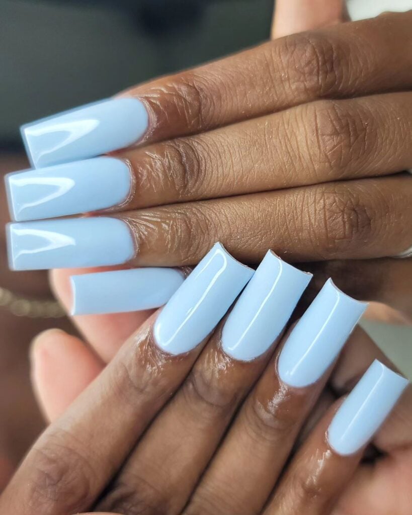 Mãos de pele preta com unha longa e quadrada azul-claro 