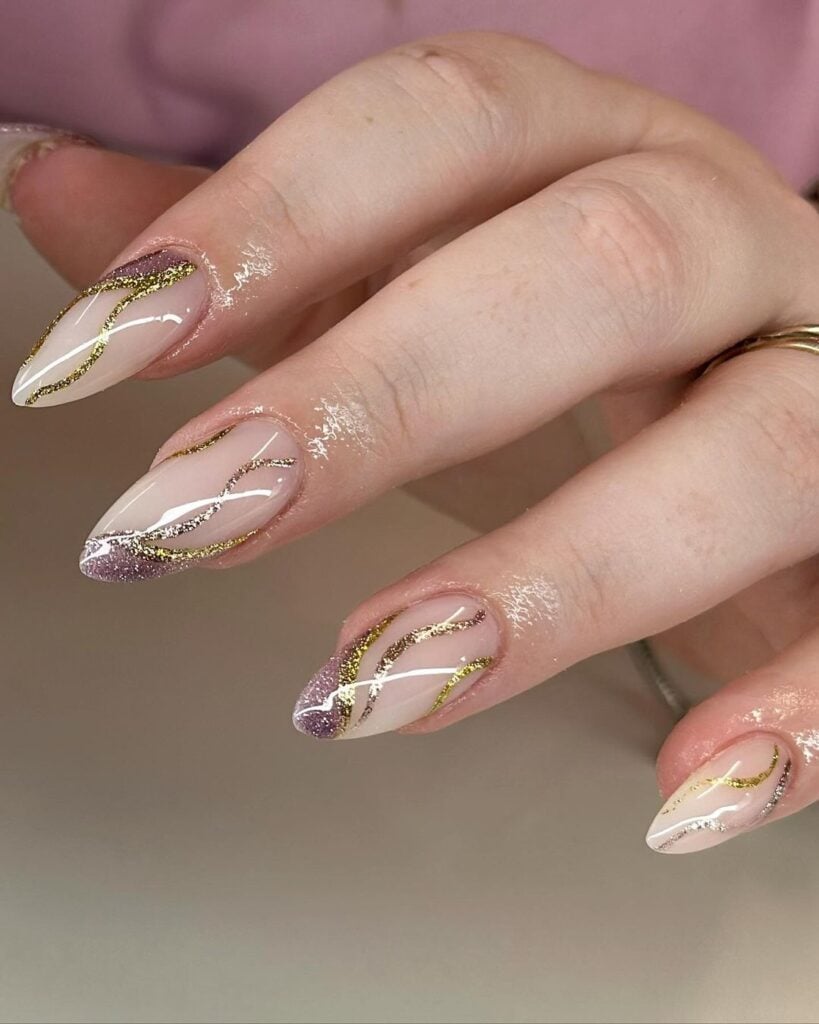 Mão de pele branca com unha stiletto nude com linhas metálicas