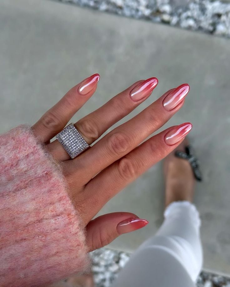 Mão de pele branca, com anel de brilhante e unha amendoada ombré rosa croamada 