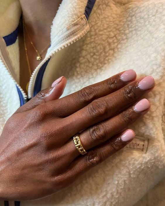 Mão de pele negra com unha curta e rosa
