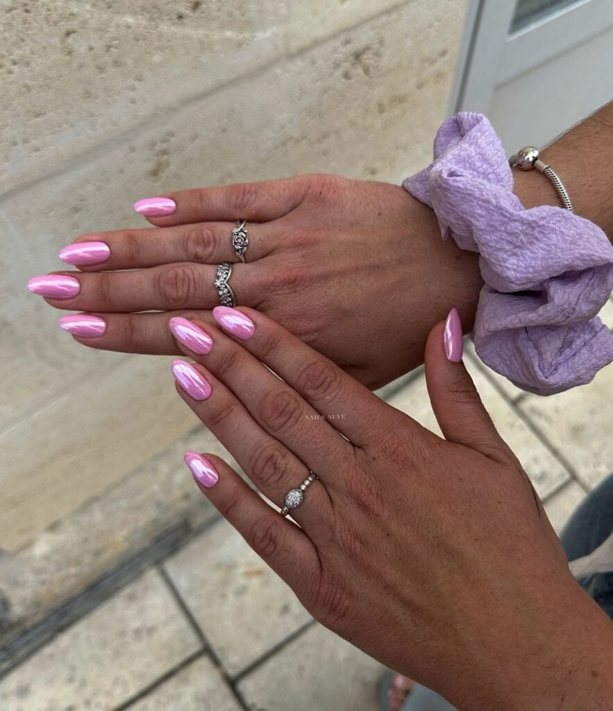 Mãos com anéis prata e unha amendoada rosa perolada