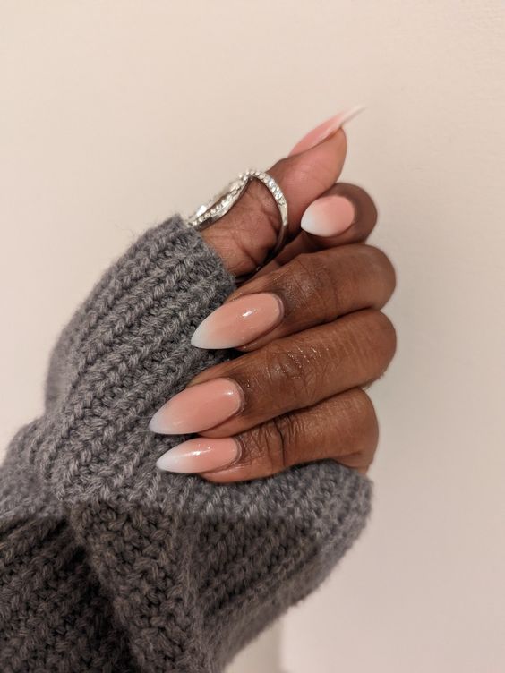 Mão de pele preta com unha stiletto nude e branca ombré 