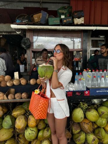Mulher jovem e magra bebendo água de coco