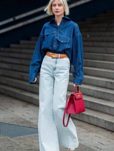 Mulher jovem, alta e magra com cabelo loiro curto. Elas veste look all jeans.