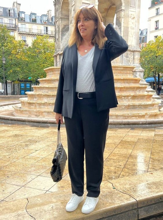 Look com blazer e calça preta, tênis branco e bolsa.