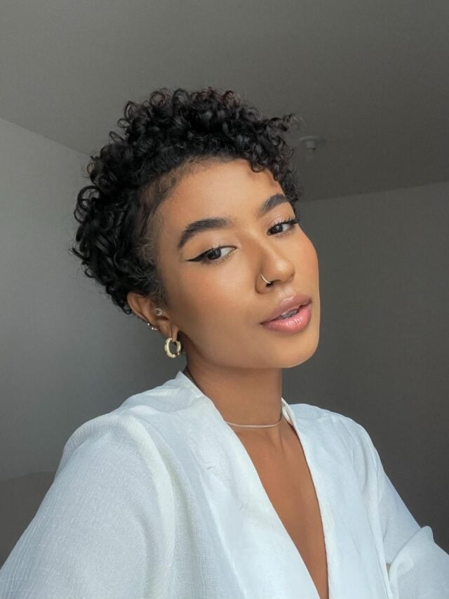 Mulher negra com cabelo cacheado em corte bixie