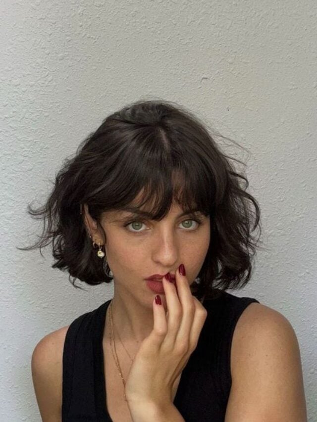 Mulher branca, com cabelo castanho, curto, repicado e com franja