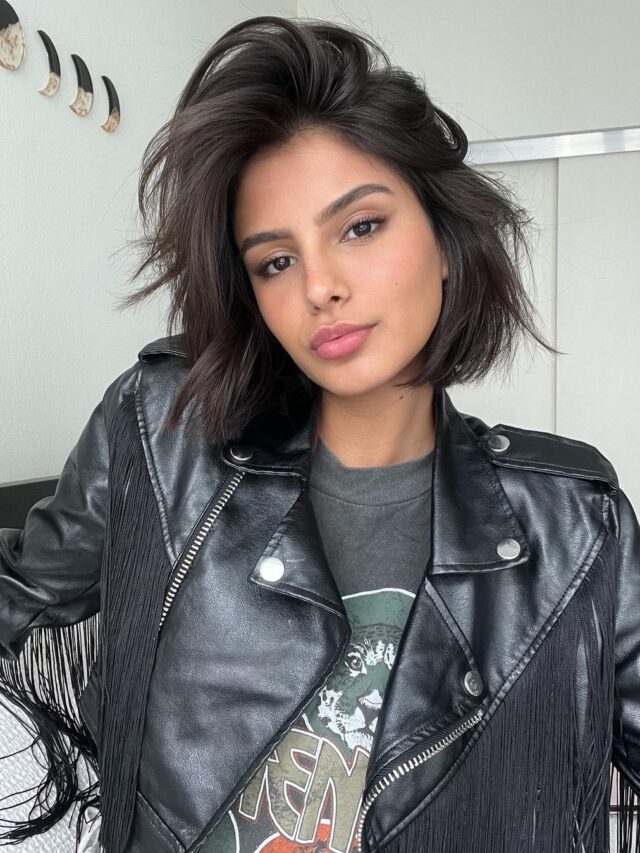 Mulher branca, com cabelo curto, liso, preto e chanel, com repicado