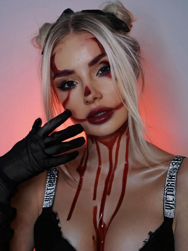 Mulher de pele branca, com cabelo meio-preso e maquiagem de Halloween com sangue falso