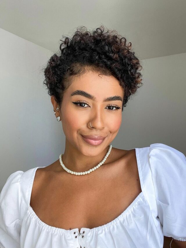 Mulher negra com cabelo cacheado em corte bixie