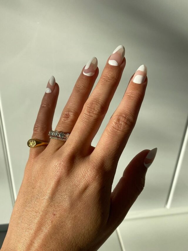 Mão de pele branca, com anéis e unha amendoada com decoração orgânica branca