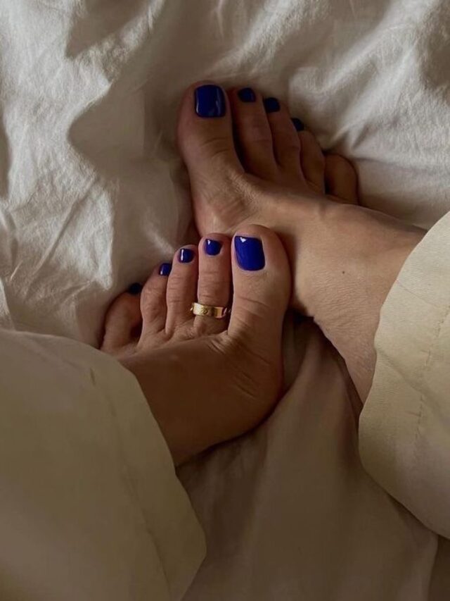 Pés de pele branca, com anel e unha azul-escuro