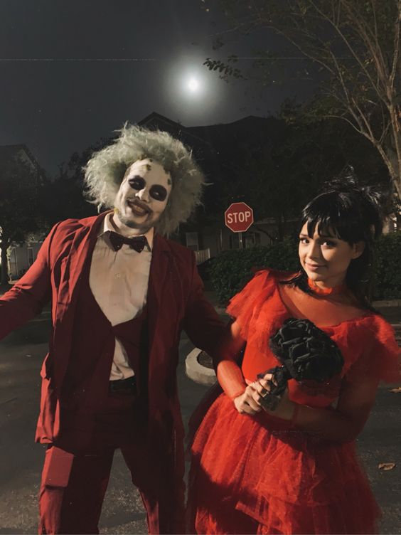 Casal vestido para o halloween. Eles estão vestidos de Beetlejuice e Lydia.