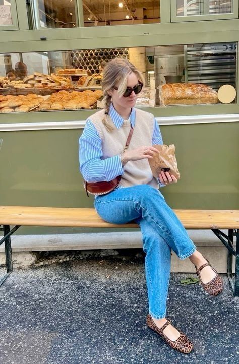 Mulher jovem magra e de pele clara com calça jeans, camisa e sapatilha de oncinha.
