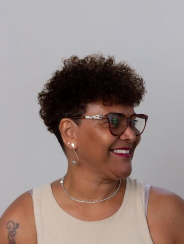 Mulher negra com cabelo bixie, crespo e castanho