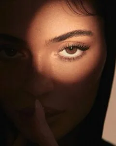 Kylie Jenner, com sombra no rosto e luz apenas no olhar