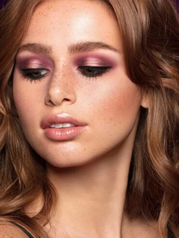 Mulher de pele branca, com cabelo solto e acobrado, e maquiagem com sombra marsala