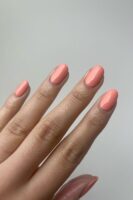 Mão de pele clara com unha amendoada pêssego