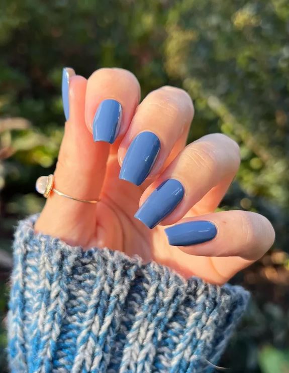 Mão de pele branca, com acessórios e unha bailarina azul jeans