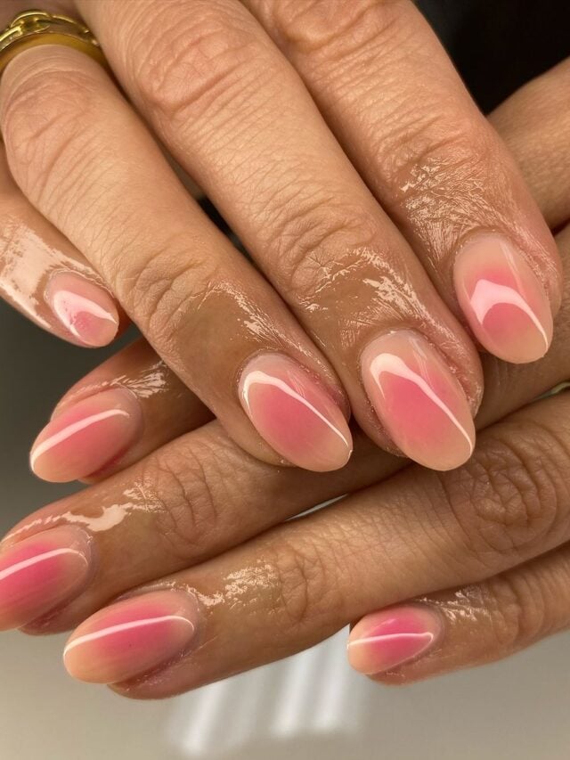 Mão de pele branca, com unha curta e amendoada, com esmalte branco e rosa em nail art aura nails
