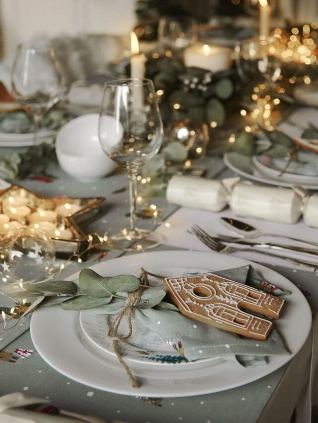 Mesa posta de Natal, com guardanapo verde e ramo de planta, com biscoito decorado
