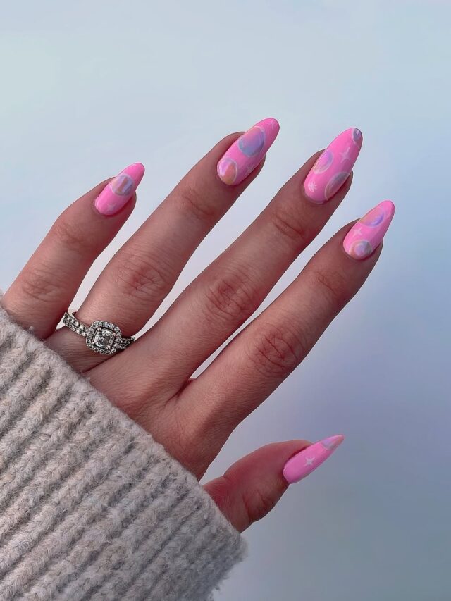 Mão de pele branca, com anel em prata e unha amendoada rosa com bolhas para decorar