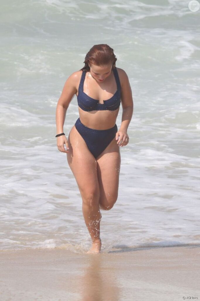 Larissa Manoela na praia, usando biquíni de cintura alta na cor azul.