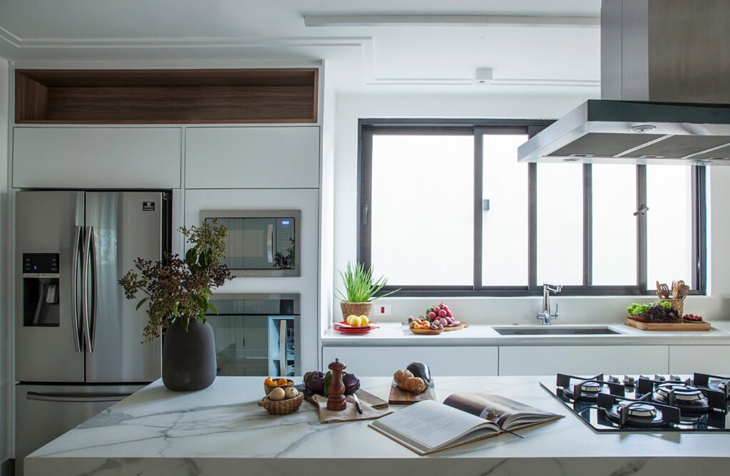 Cozinha com móveis brancos, com bancada branca