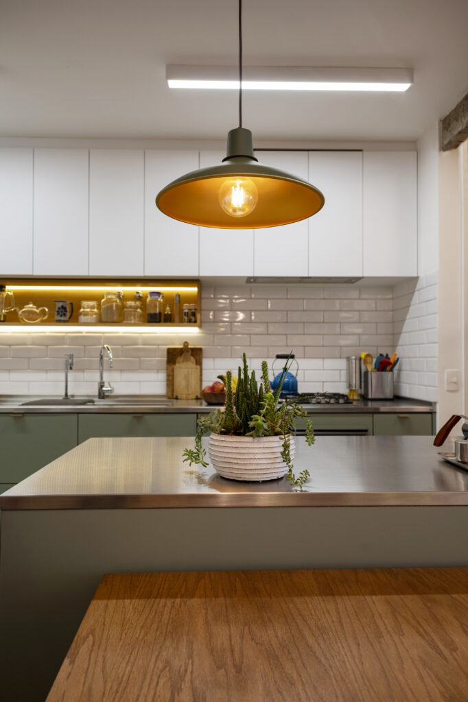 Cozinha com armários verde-menta e branco com pendente acima da bancada