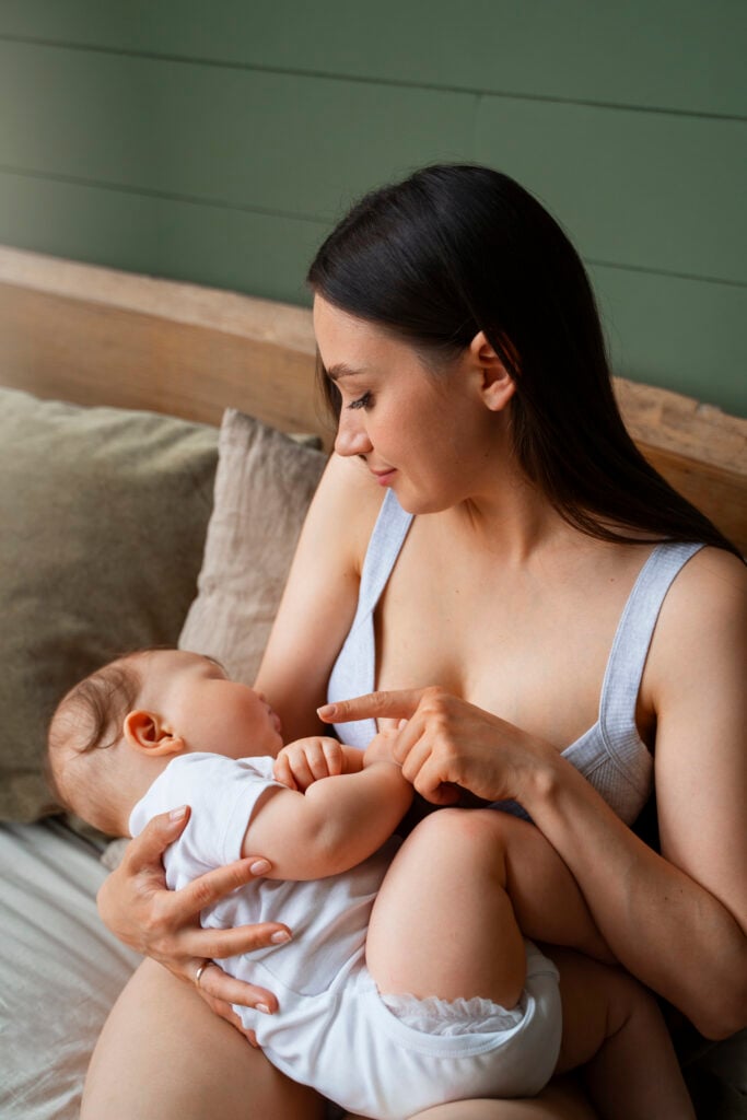 Mulher jovem de pele clara com bebê de aproximadamente 5 meses.