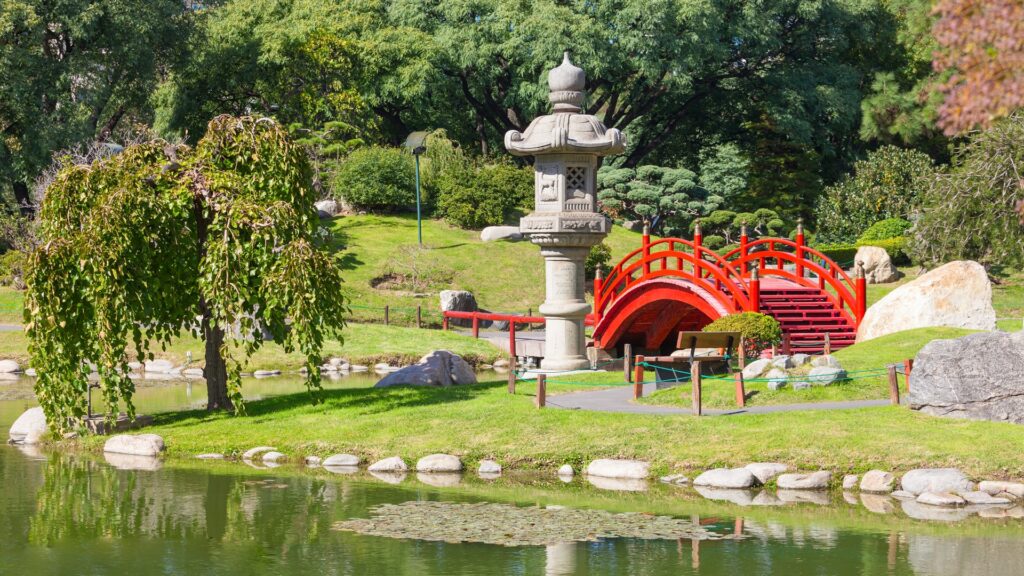 Jardim japonês, com ponte vermelha, esculturas, pedras e árvores