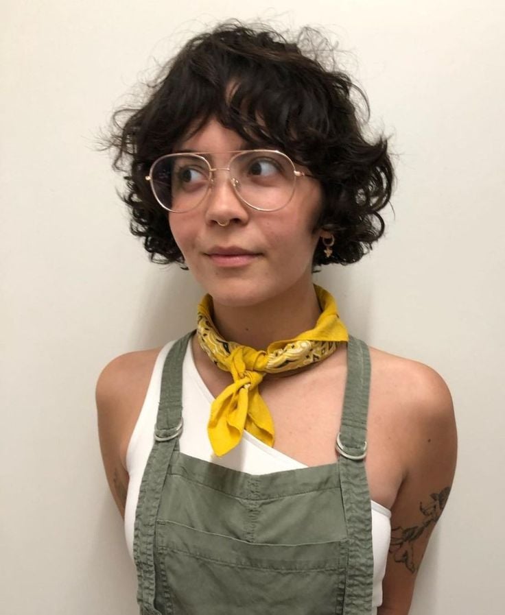 Mulher de pele clara, com look colorido e cabelo french bob escuro