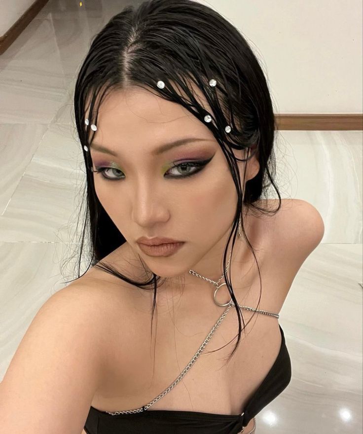 Mulher de descendência oriental, com cabelo escuro e maquiagem dark siren 