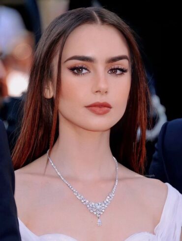 Lily Collins, com vestido branco, acessórios em prata, cabelo liso e delineado para olhos redondos