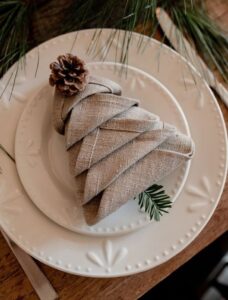 Pratos decorados com guardanapo dobrado no formato de uma árvore de Natal