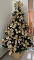 Árvore de Natal verde com bolas e laços dourados