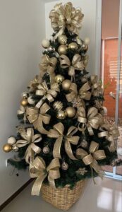 Árvore de Natal verde com bolas e laços dourados