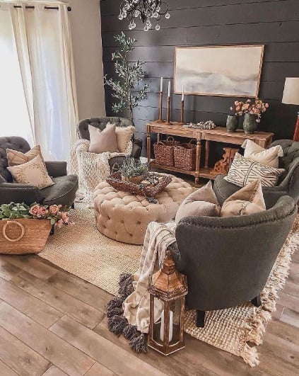 Sala de estar com poltronas cinza e mesa de centro no estilo capitonê