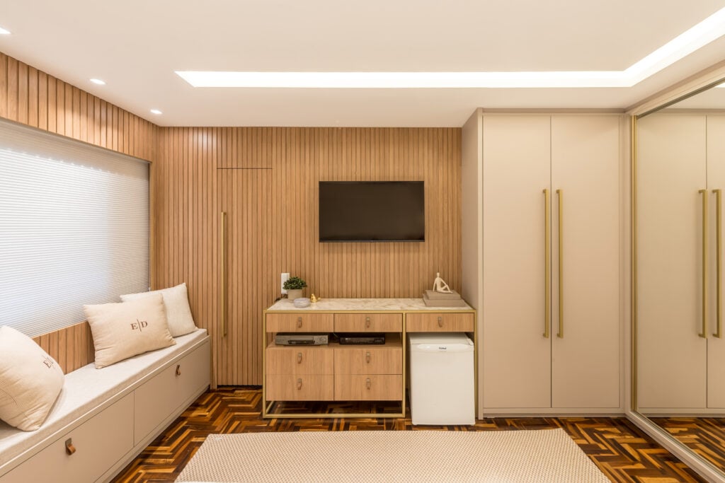 Quarto com estilo sofisticado, cama de casal, mesas de cabeceira e guarda-roupa com espelho, ripado na parede e gesso com sanca iluminada